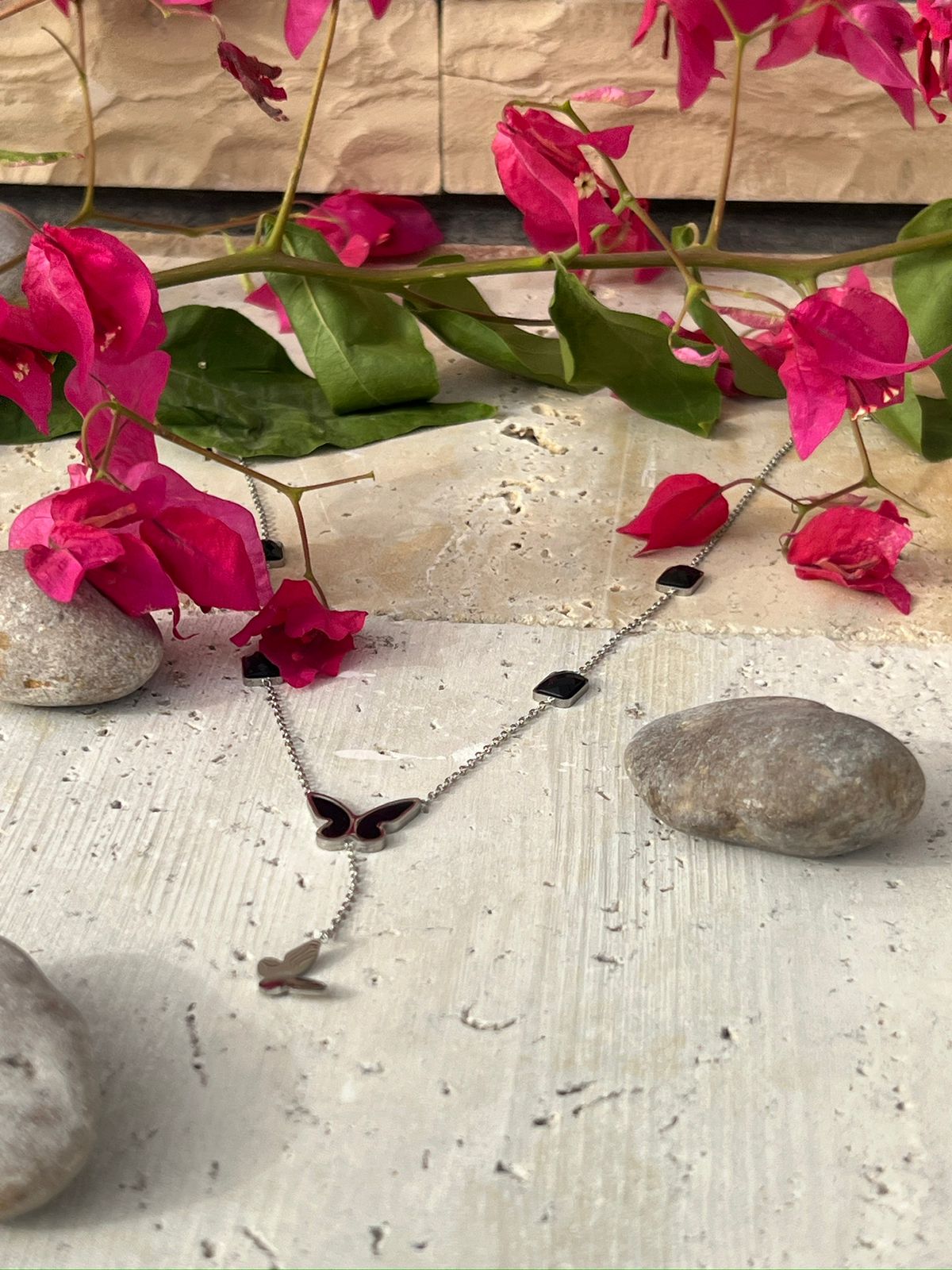 Butterfly pendant necklace with black charm accents — a piece of minimalist butterfly jewelry and nature-inspired design for everyday wear.