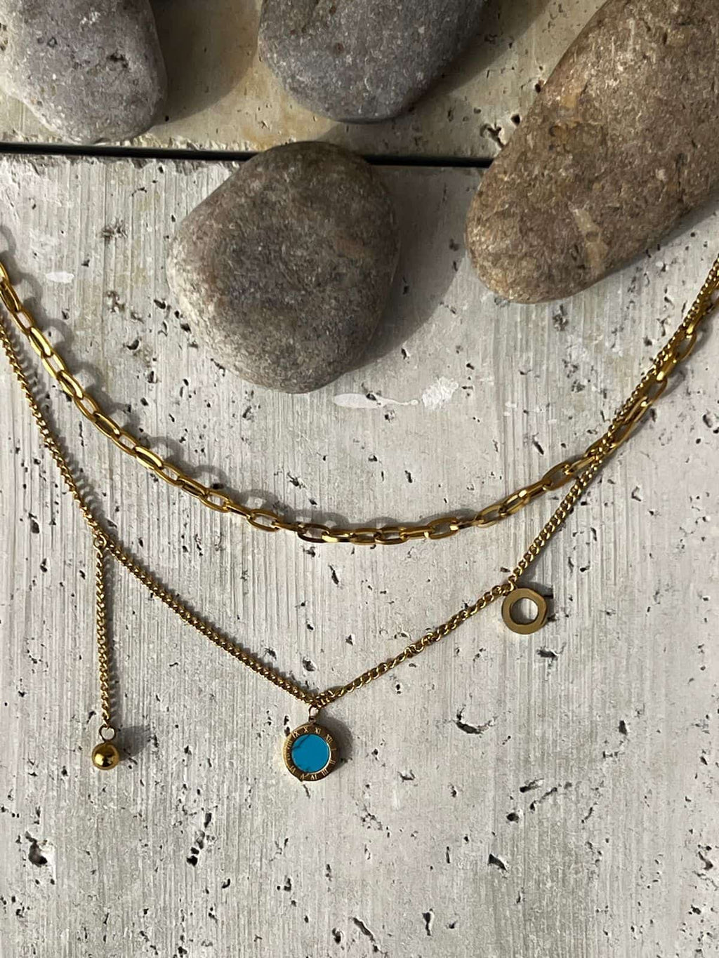 Layered gold necklace featuring a turquoise pendant — a piece of minimalist layered jewelry and an everyday statement necklace for women.