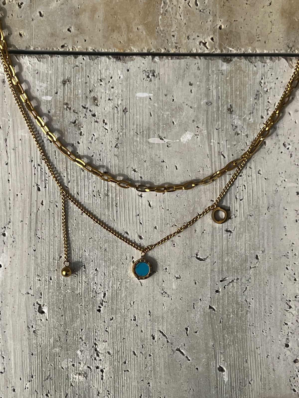 Layered gold necklace featuring a turquoise pendant — a piece of minimalist layered jewelry and an everyday statement necklace for women.
