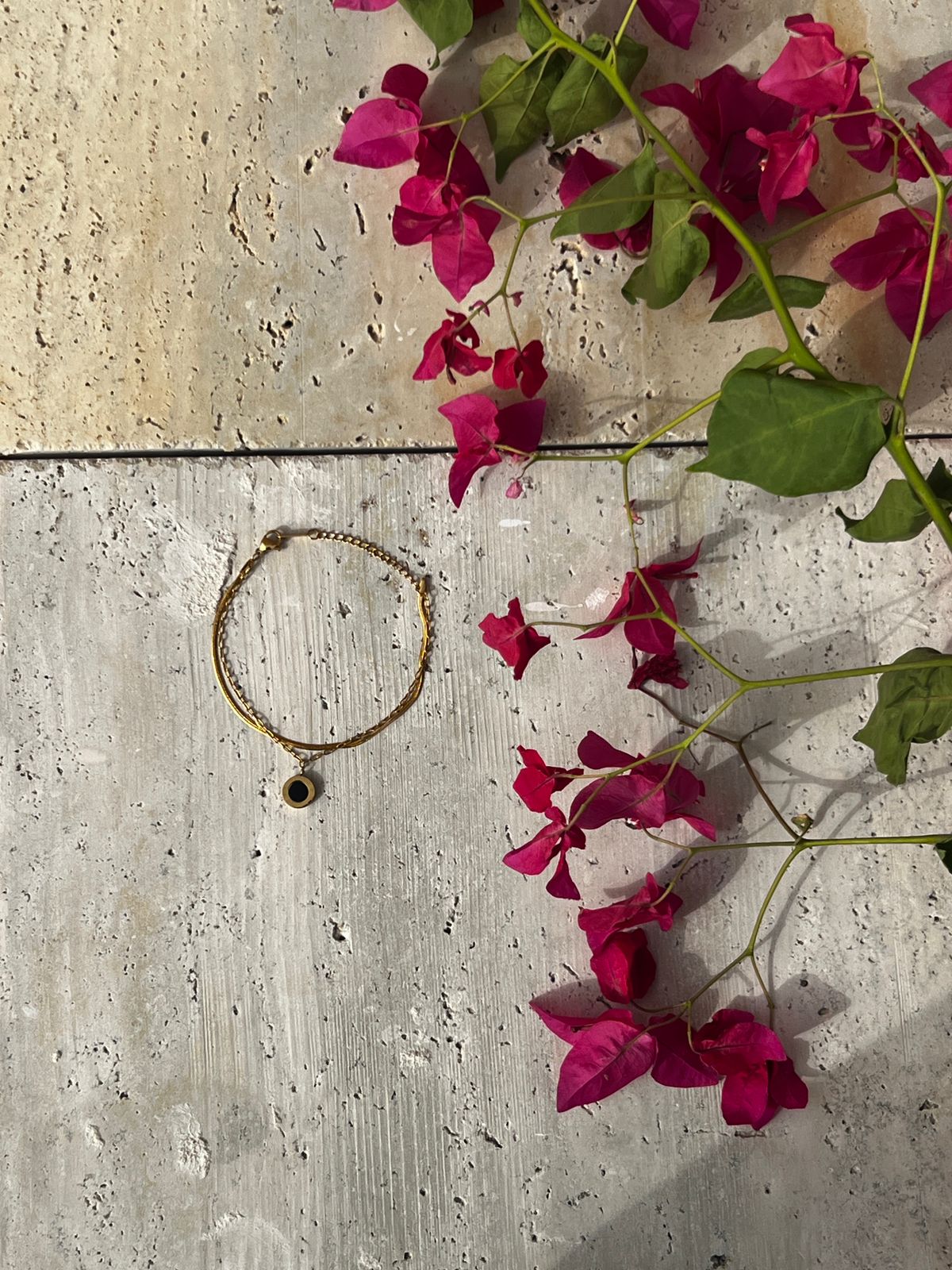 Black charm bracelet with a circular pendant on a minimalist gold chain — a modern fashion accessory and everyday wear bracelet for women.