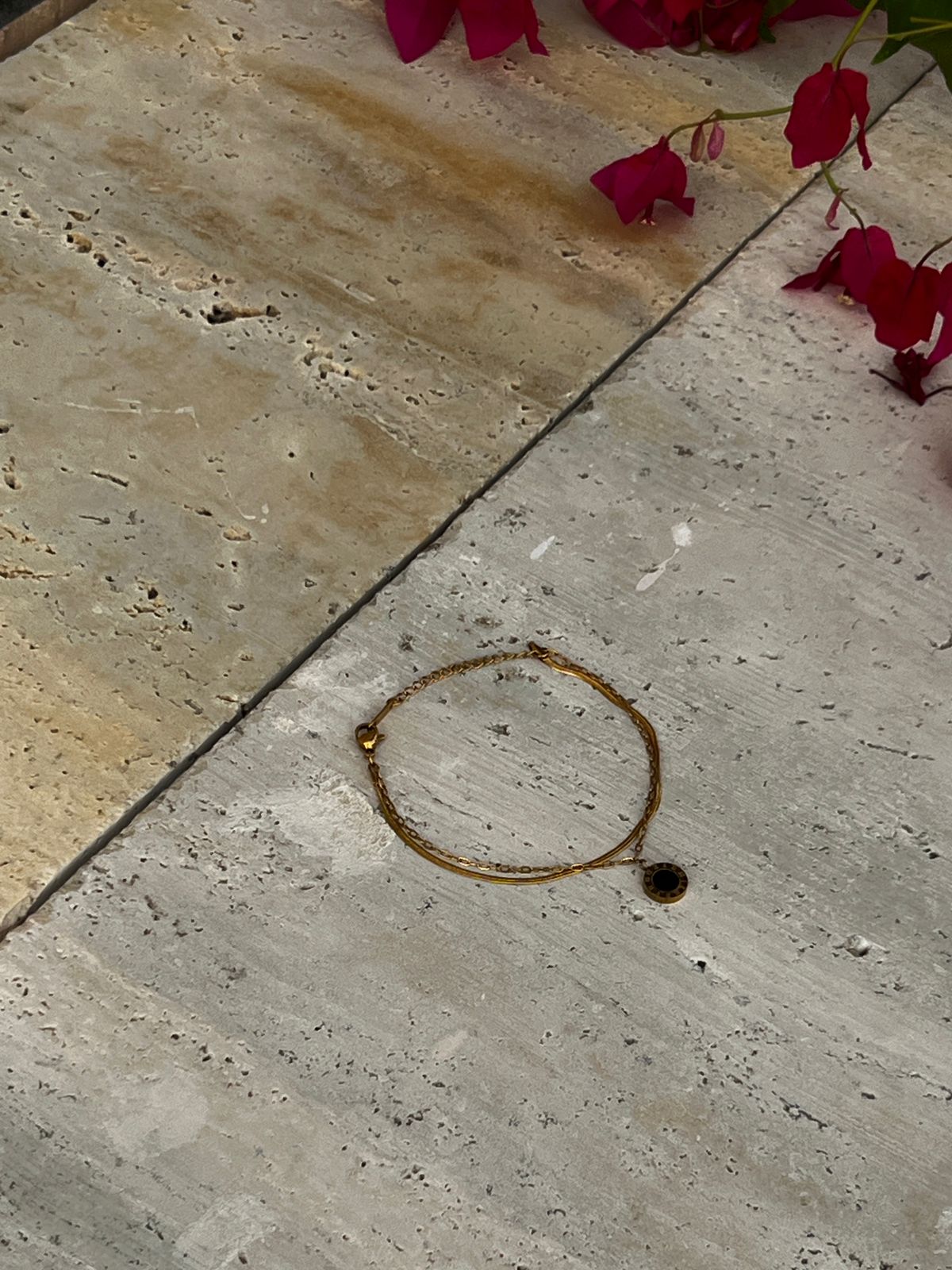 Black charm bracelet with a circular pendant on a minimalist gold chain — a modern fashion accessory and everyday wear bracelet for women.