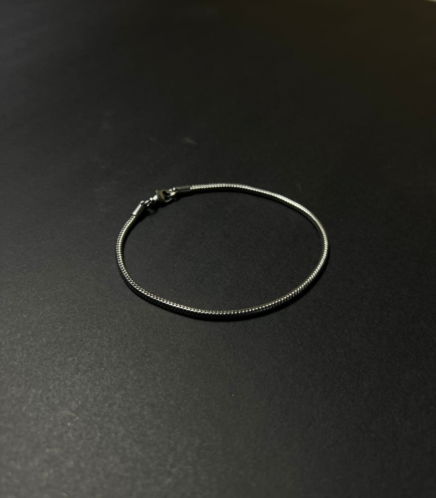 Silver bracelet on a dark gray background